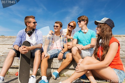 Image of group of smiling friends sitting on city street