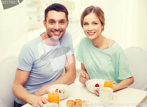 Image of smiling couple having breakfast at home