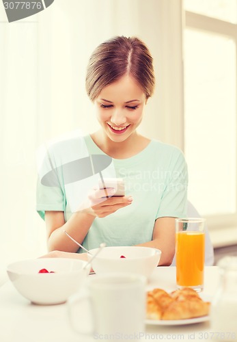 Image of smiling young woman with smartphone reading news