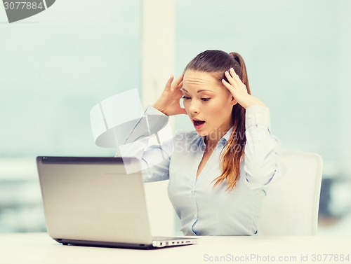 Image of stressed woman with laptop