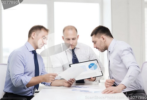 Image of serious businessmen with papers in office