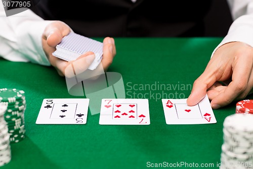 Image of holdem dealer with playing cards and casino chips