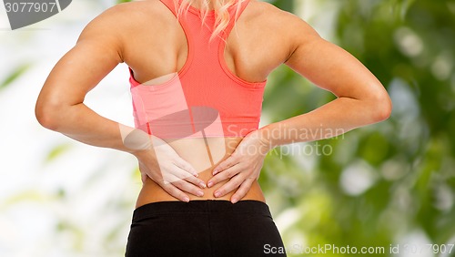 Image of close up of sporty woman touching her back