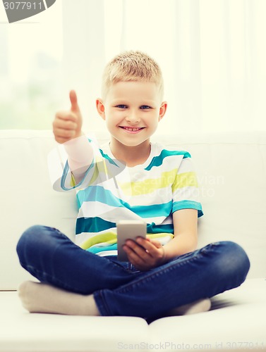 Image of smiling boy with smartphone showing thumbs up