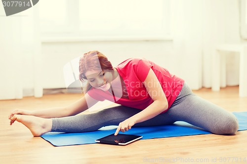 Image of smiling teenage girl streching on floor at home