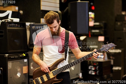 Image of musician or customer with guitar at music store