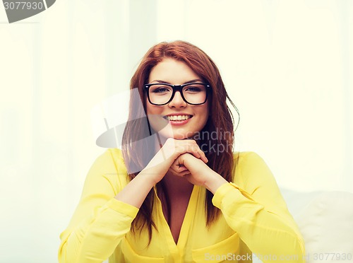 Image of smiling teenage girl in eyeglasses at home
