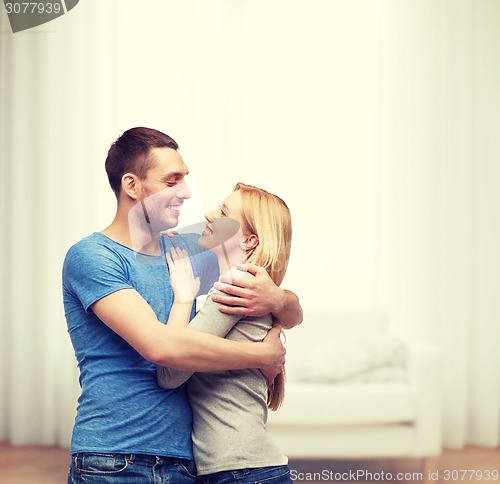 Image of smiling couple hugging and looking at each other