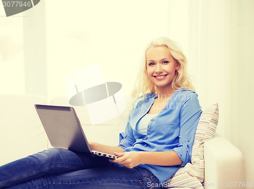 Image of smiling woman with laptop computer at home