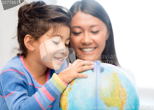 Image of mother and daughter with globe