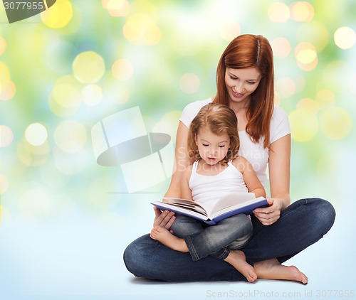 Image of happy mother with adorable little girl and book