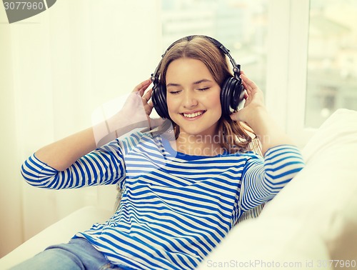 Image of smiling young girl in headphones at home