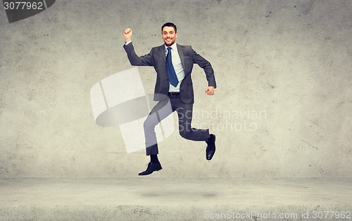 Image of smiling businessman jumping