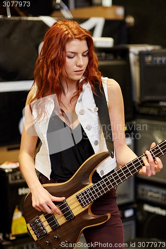 Image of musician or customer with guitar at music store