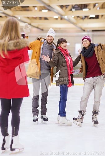 Image of happy friends taking photo on skating rink