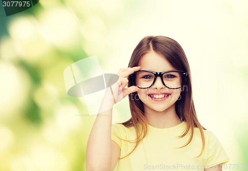 Image of smiling cute little girl in black eyeglasses