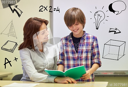 Image of school boy with notebook and teacher in classroom