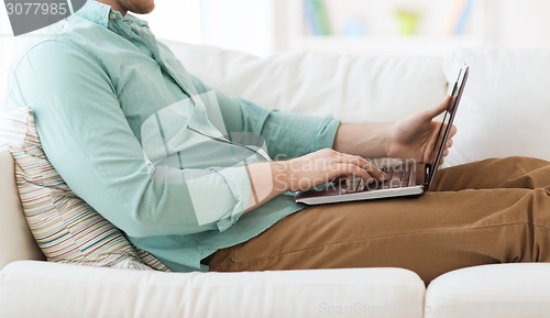 Image of close up of man working with laptop at home