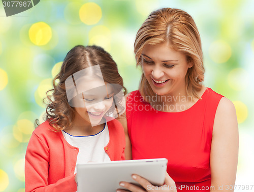 Image of mother and daughter with tablet pc over green