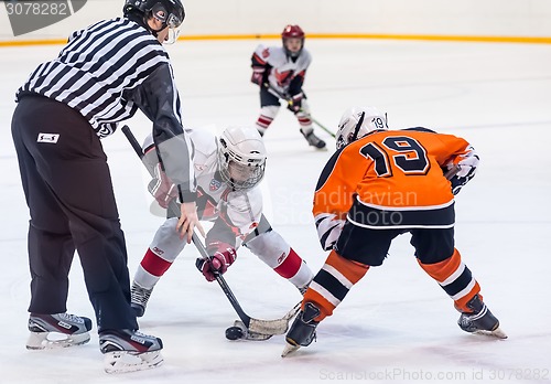 Image of Puck playing between players of ice-hockey teams