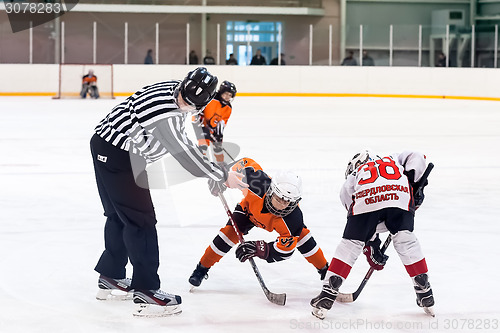 Image of Puck playing between players of ice-hockey teams