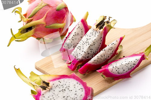 Image of Four Fruit Wedges Of A Cut Pitaya On Cutting Board