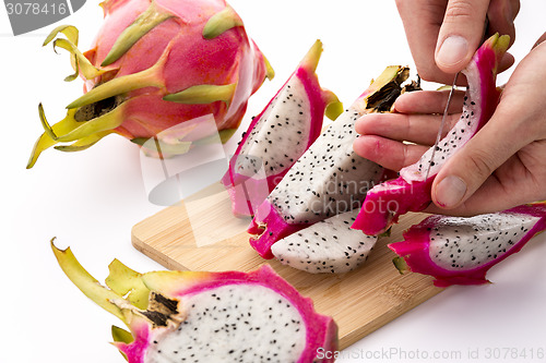 Image of Hands Removing Pulp From A Pitaya Fruit Wedge