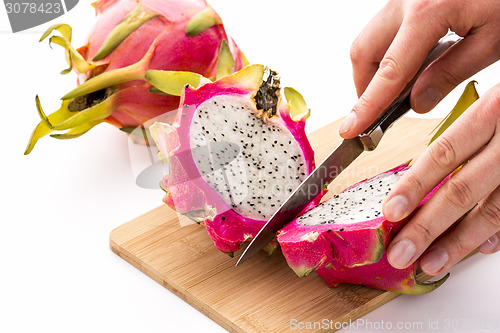 Image of Hands Of A Chef Cutting A Dragonfruit In Half
