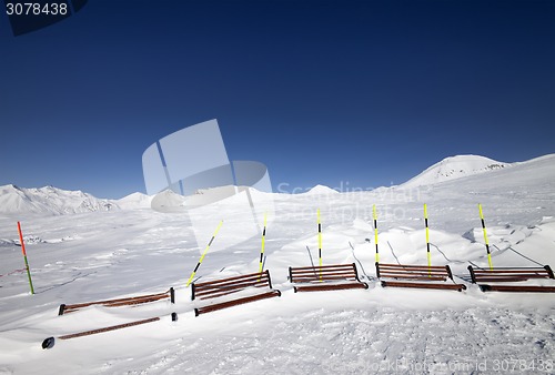Image of Ski slope and wooden benches in snow