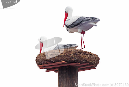 Image of Sculpture of storks in the nest on a white background.