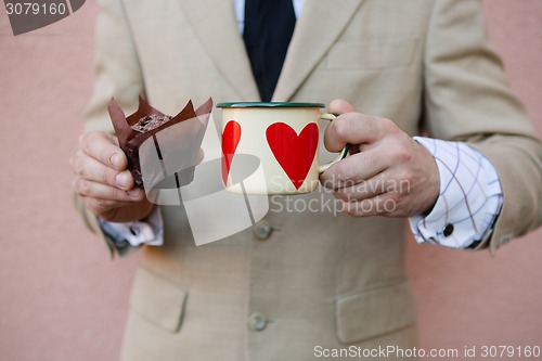 Image of man holding hot cup of coffee