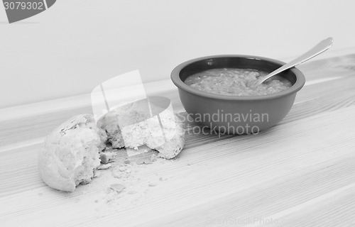 Image of Soup served with a torn crusty bread roll