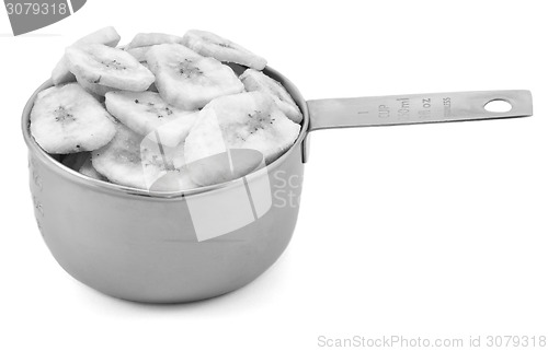 Image of Dried banana chips in a cup measure