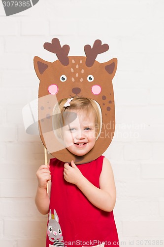 Image of Little girls holding deer mask on white background