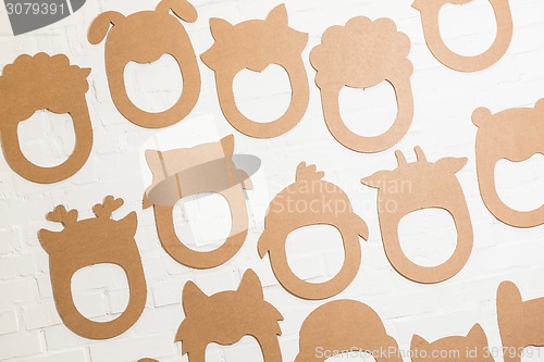 Image of Set of cardboard masks on a white brick wall.