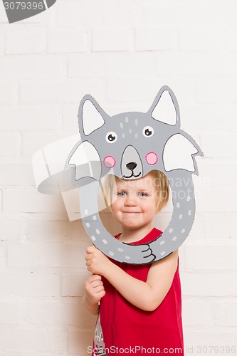 Image of Little girls holding wolf mask on white background