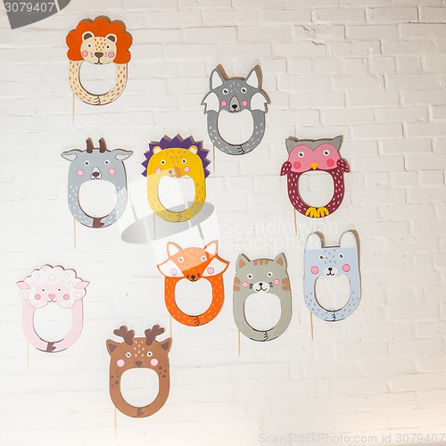 Image of Set of cardboard masks on a white brick wall.