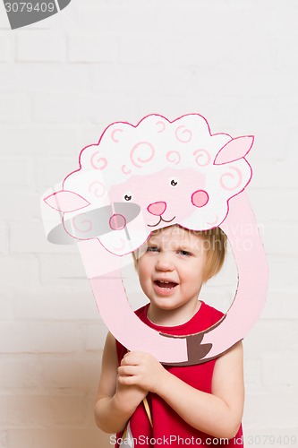 Image of Little girls holding sheep mask on white background