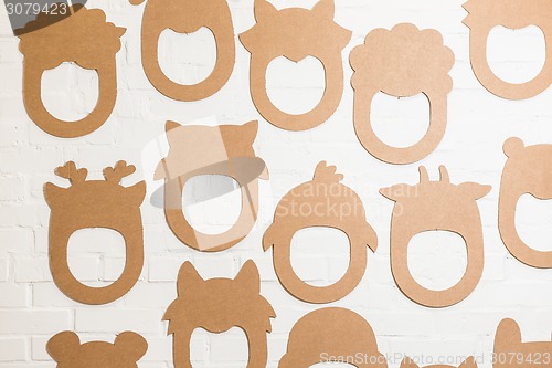 Image of Set of cardboard masks on a white brick wall.