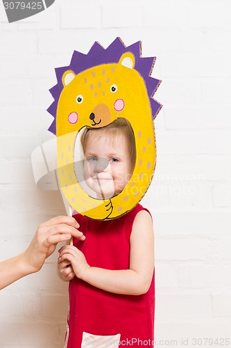 Image of Little girls holding hedgehog mask on white background