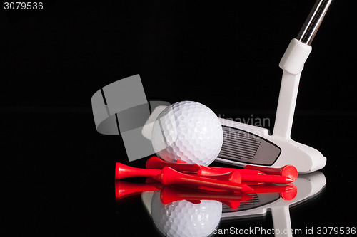 Image of Golf putter and gold equipments on the black glass desk