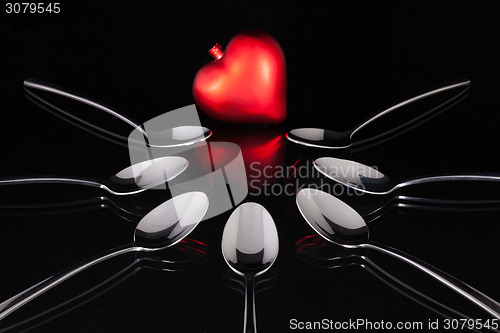 Image of Teaspoons and love symbol on the black glass desk