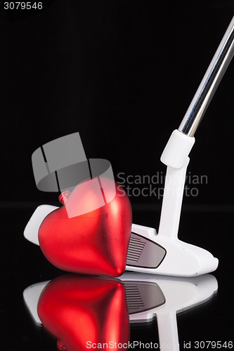 Image of Golf putter and love symbol on the black glass desk