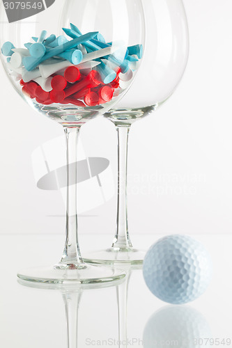 Image of Two glasses of wine and golf equipments