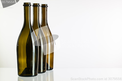 Image of Empty bottles of wine on a glass desk