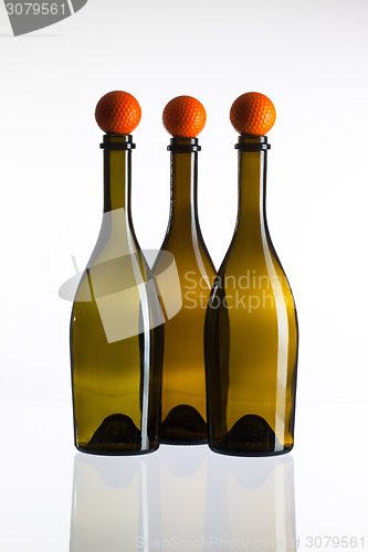 Image of Empty three  wine bottles and golf balls