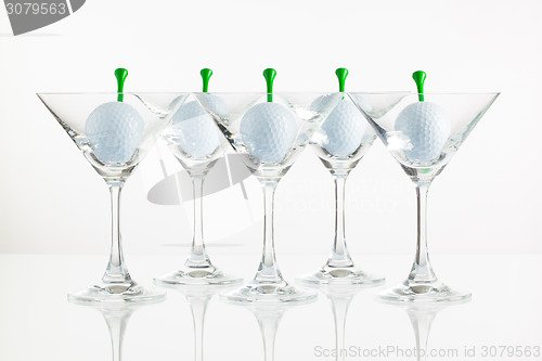 Image of Five glasses of champagne and golf equipments 