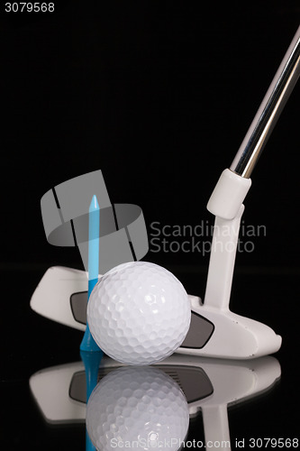 Image of Golf putter and gold equipments on the black glass desk