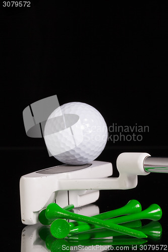 Image of Golf putter and gold equipments on the black glass desk