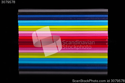 Image of Twelve different color diaries on a black glass table
